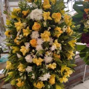 Coroa de rosas amarelas, lírios amarelos e complementos
